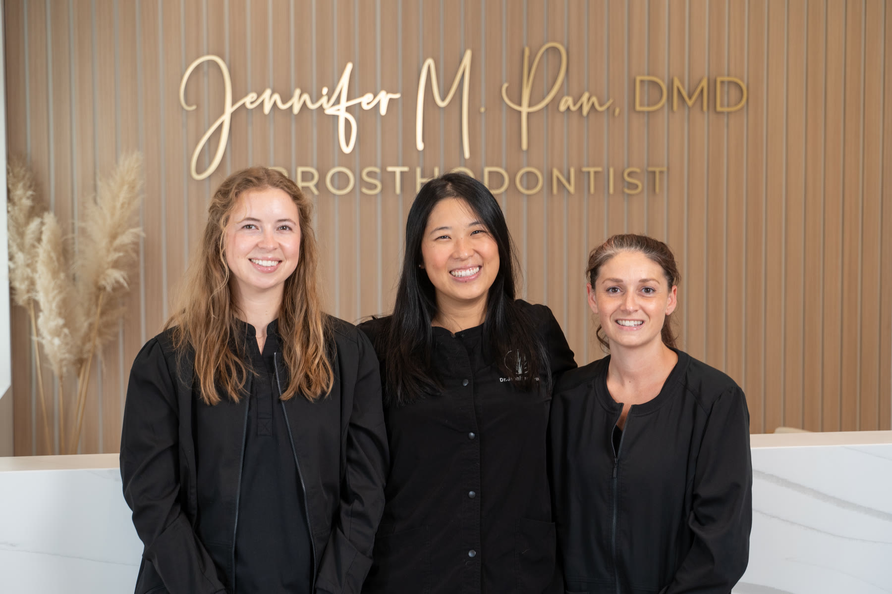 Tamarra, Dr. Jennifer Pan, and Tiffany at the Pan DMD front desk in Wilmington, NC