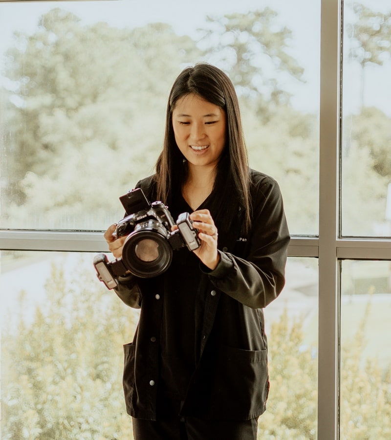 Pan-is-holding-a-camera-in-her-hands-and-happily-smiling